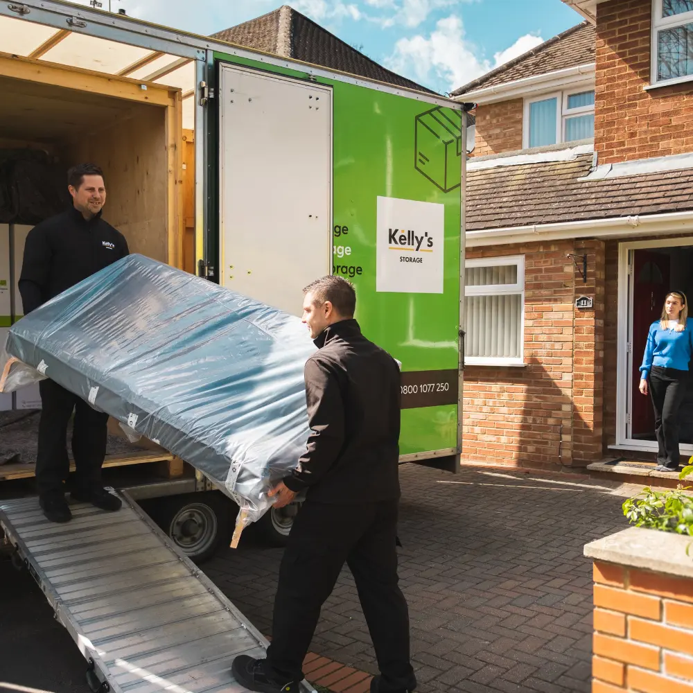Image of two self storage professionals loading a customers goods into a storage unit in Guildford